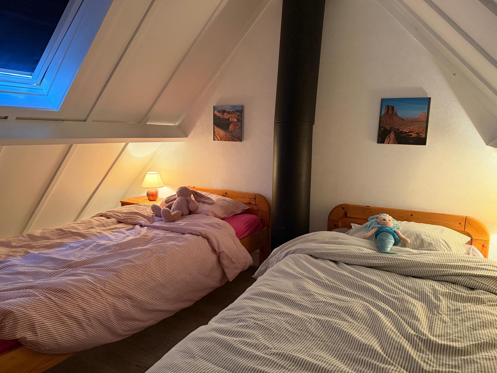 Upstairs bedroom with two single beds under the sloping roof